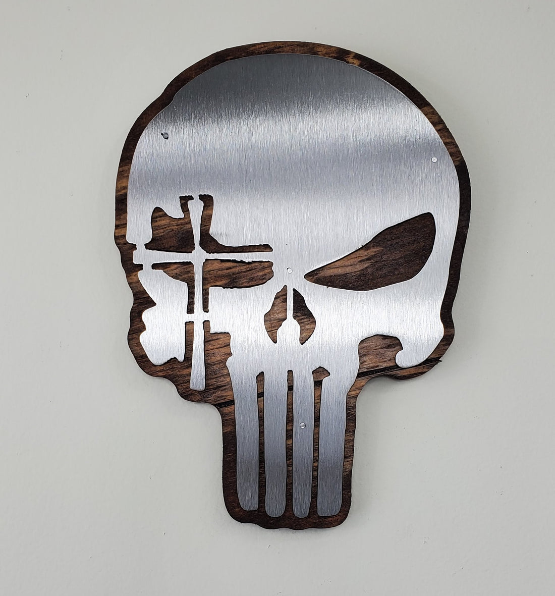 Punisher skull with a cross over an eye metal art wall hanging