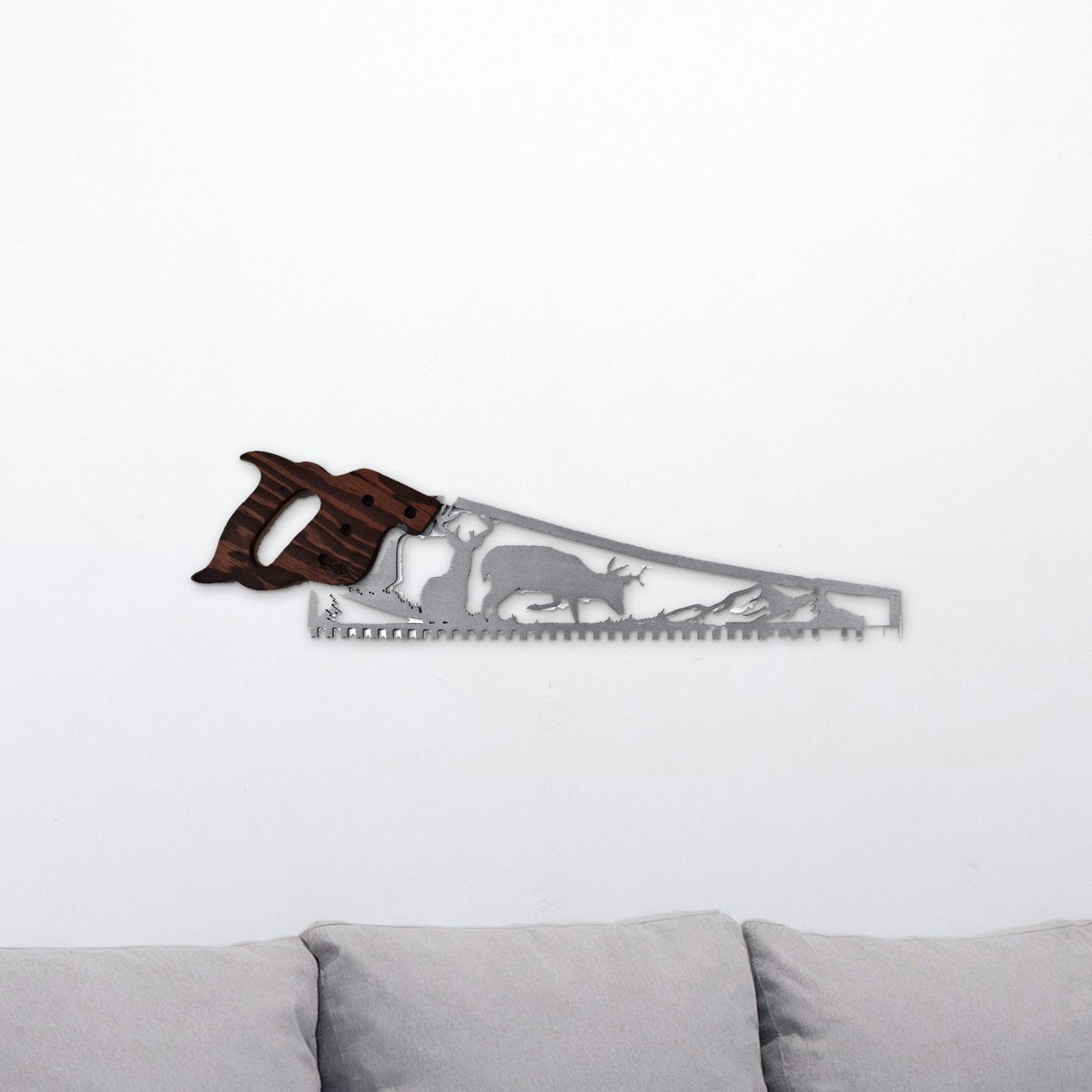 Whitetail deer hand saw wall art with two bucks, hanging above a gray couch