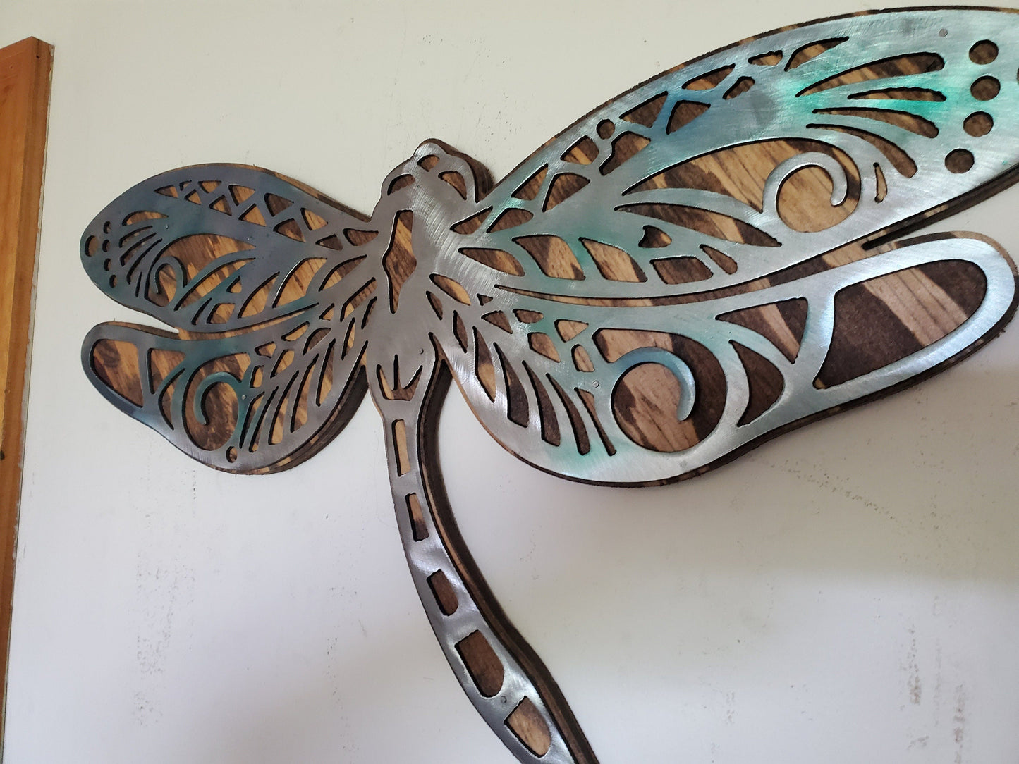  beautiful Dragonfly metal and wood wall sculpture, the perfect addition to any home looking for a unique piece of metal art home decor. This sculpture is made in our family shop in Minnesota, using rustic stained wood and clear-coated steel.