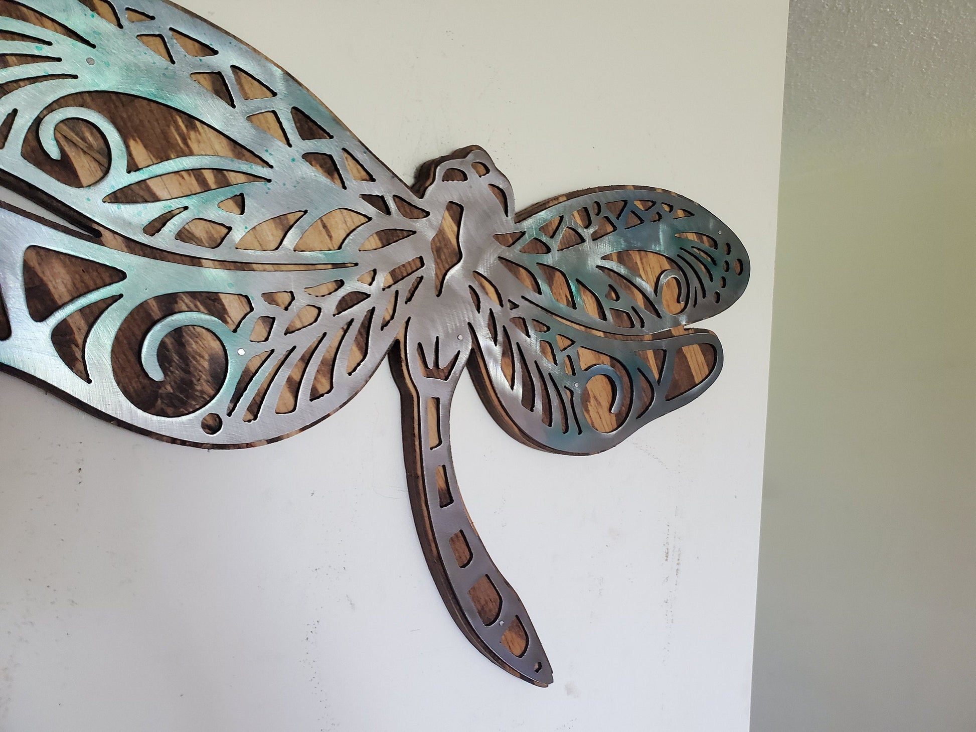  beautiful Dragonfly metal and wood wall sculpture, the perfect addition to any home looking for a unique piece of metal art home decor. This sculpture is made in our family shop in Minnesota, using rustic stained wood and clear-coated steel.