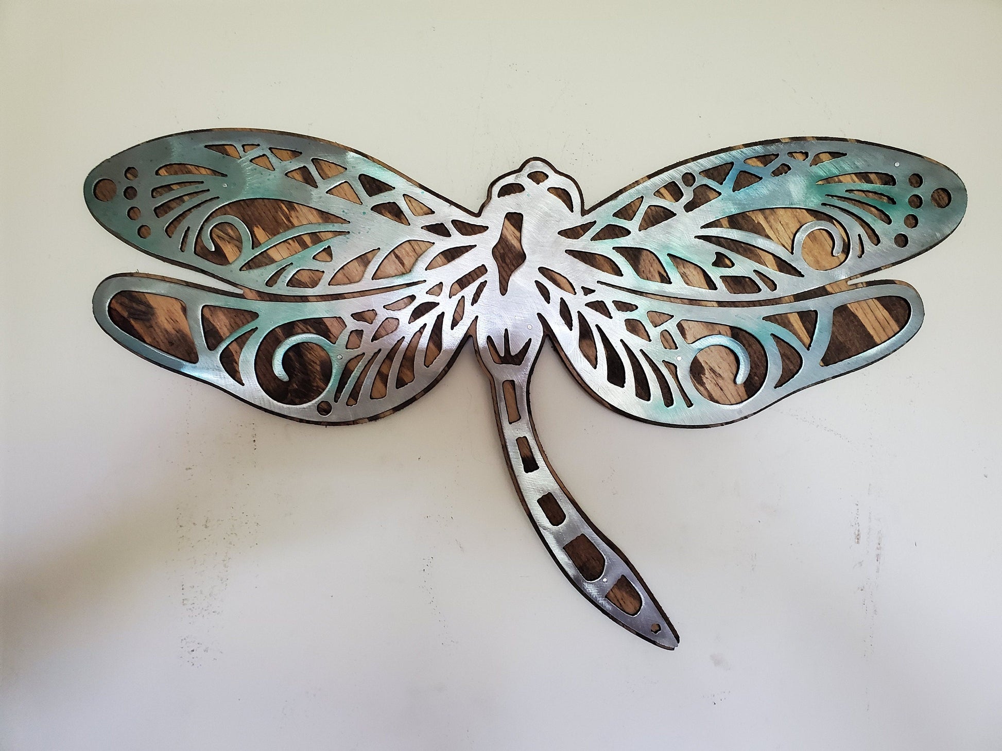  beautiful Dragonfly metal and wood wall sculpture, the perfect addition to any home looking for a unique piece of metal art home decor. This sculpture is made in our family shop in Minnesota, using rustic stained wood and clear-coated steel.