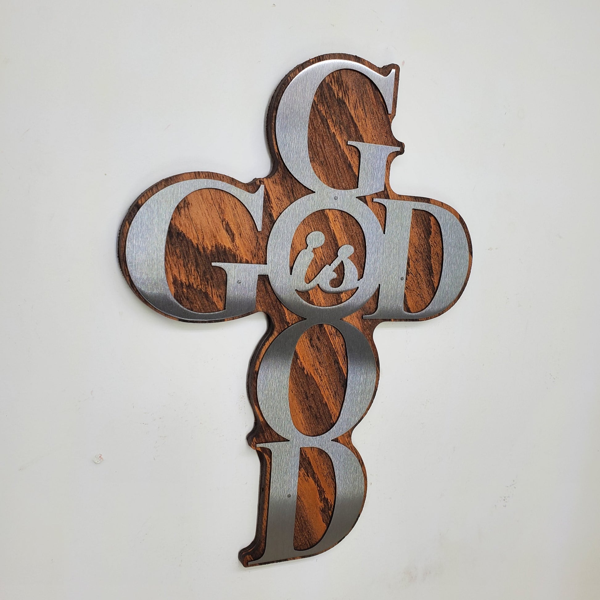 God is Good Religious Cross Sculpture Metal Art! This beautiful piece is perfect for adding a touch of inspiration to any room in your home. Made with rustic stained wood and clear-coated steel, it features a cross shape from the words "God is Good"