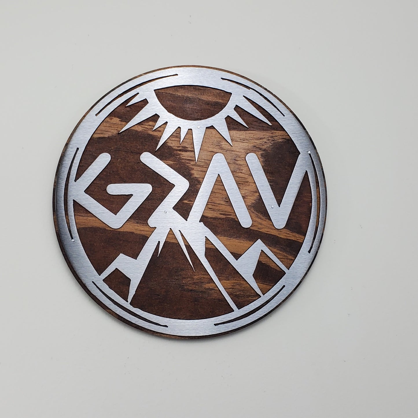 God is Greater Than the Highs and Lows Greek letters and mountains  metal art on stained wood circle design