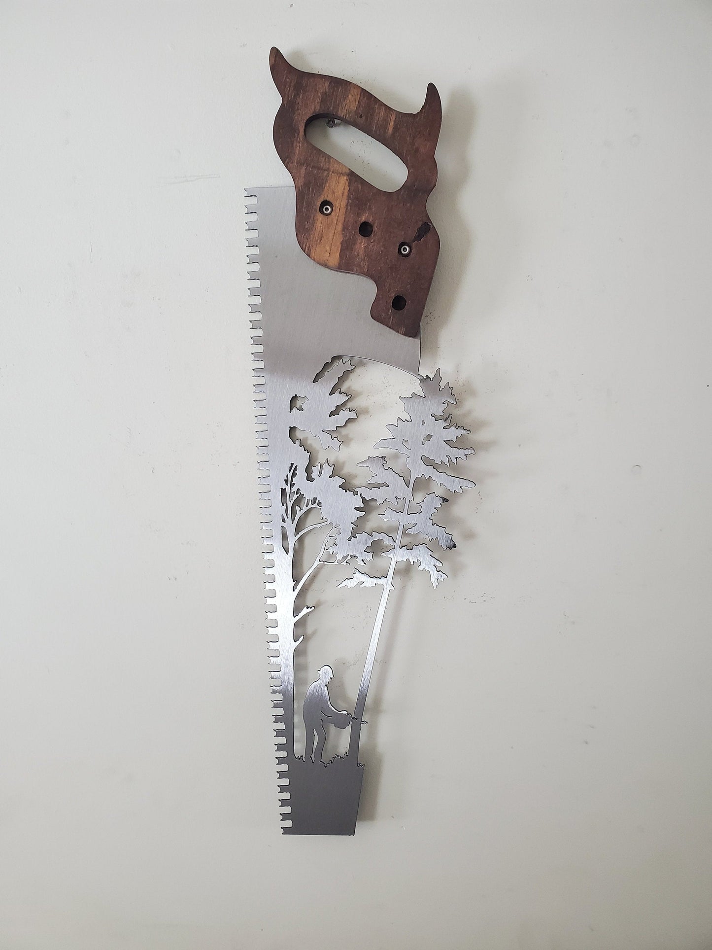 handsaw cut out with trees and lumberjack