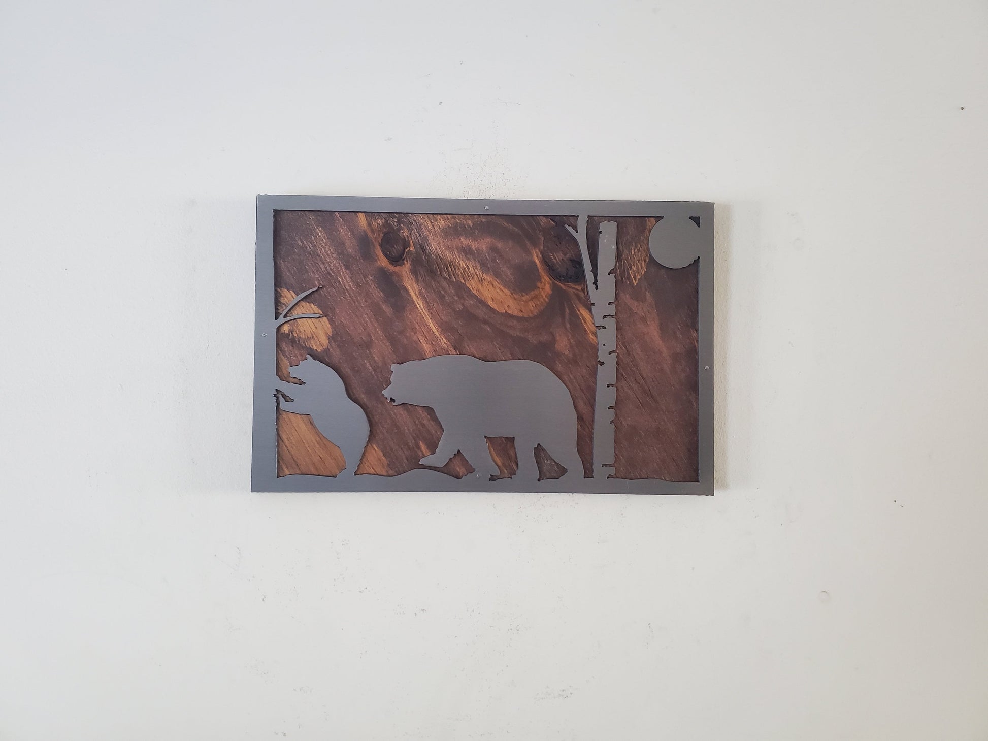 A close-up of a bear scene metal art wall decor made of clear coated steel, featuring intricate details and textures of a bear in its natural habitat. A perfect addition to any nature lover's home or office decor.