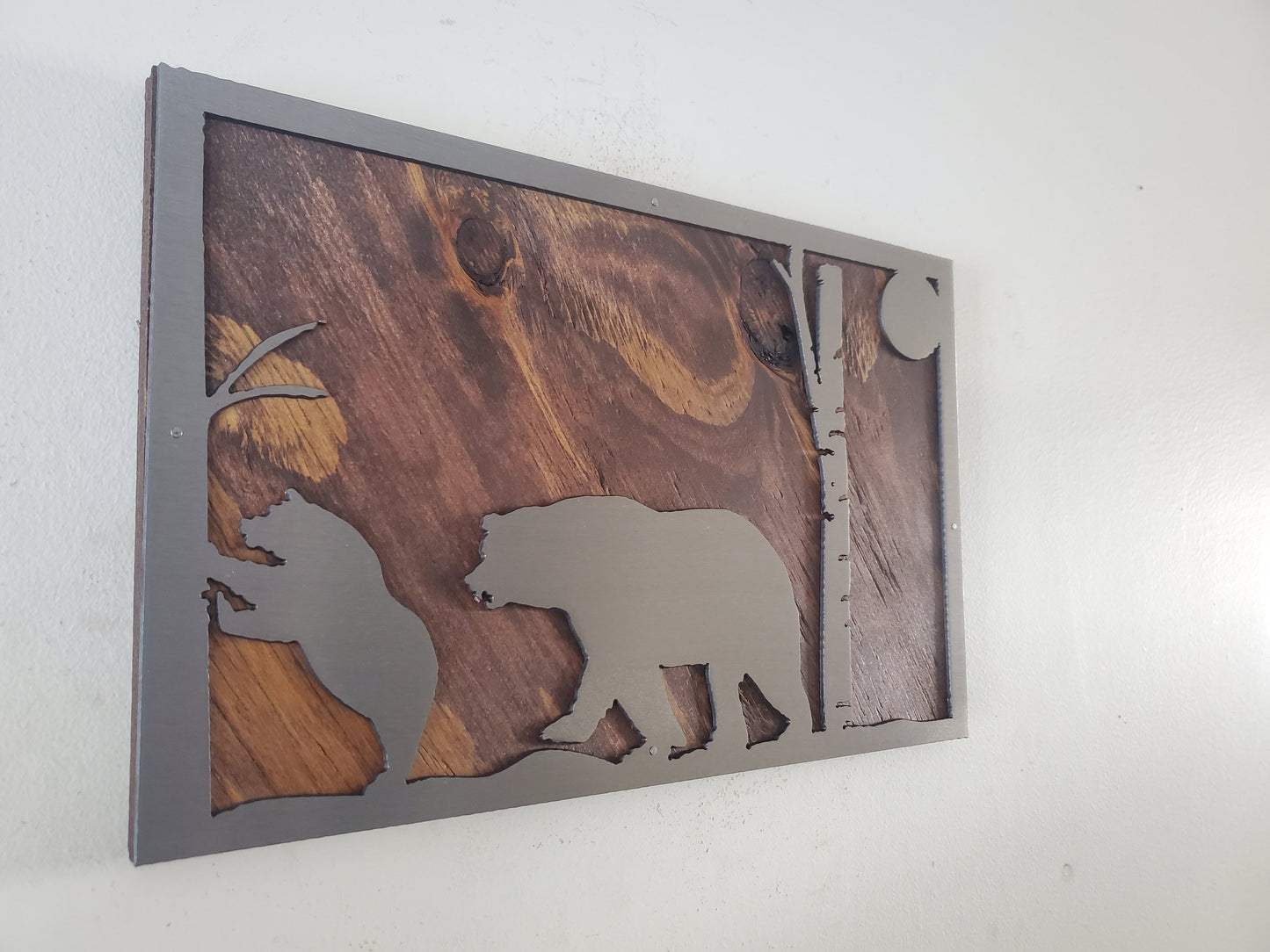 A close-up of a bear scene metal art wall decor made of clear coated steel, featuring intricate details and textures of a bear in its natural habitat. A perfect addition to any nature lover's home or office decor.