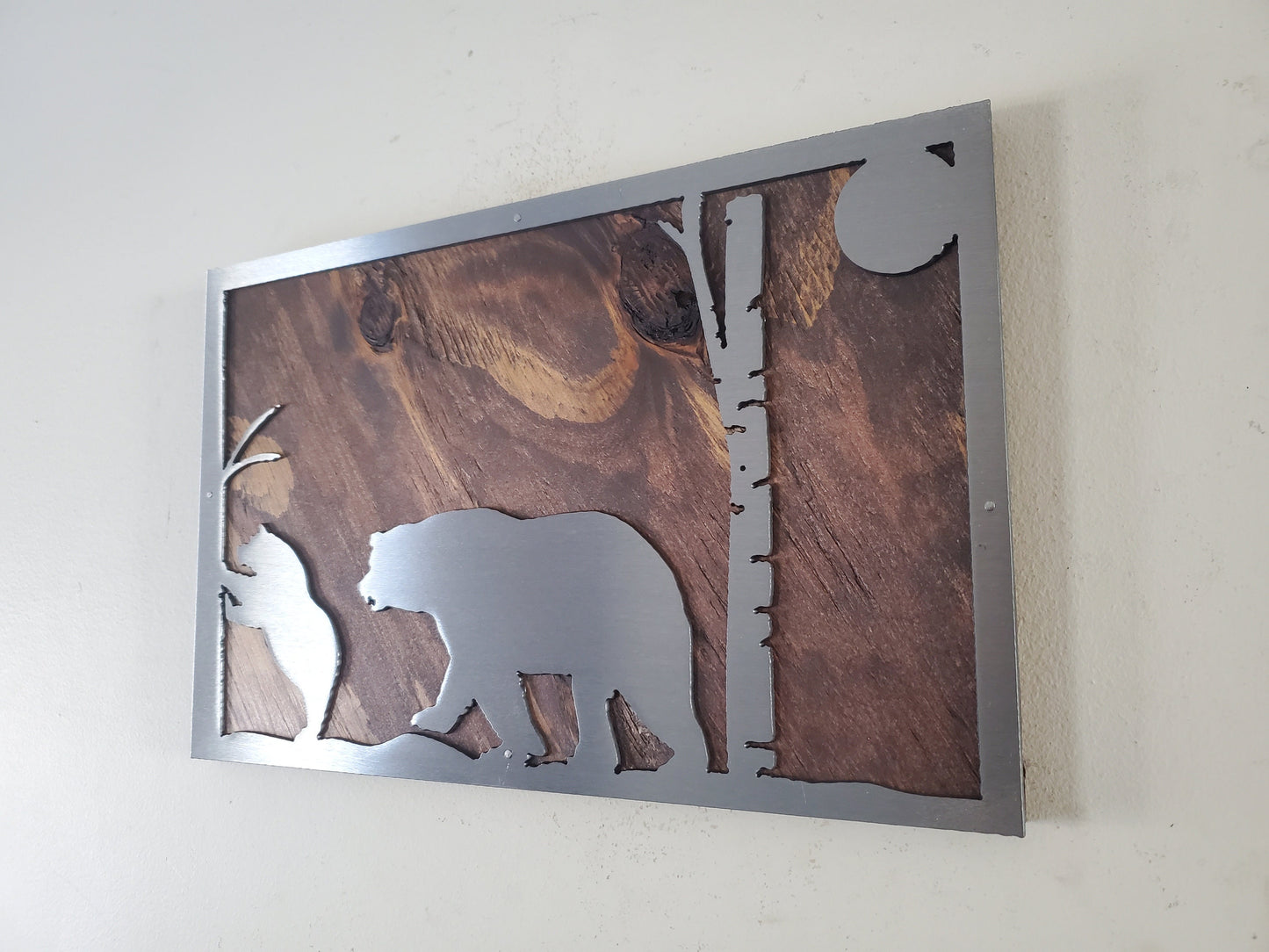 A close-up of a bear scene metal art wall decor made of clear coated steel, featuring intricate details and textures of a bear in its natural habitat. A perfect addition to any nature lover's home or office decor.