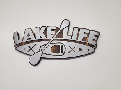 This is a Lake Life Kayak metal art wall decor on a stained wood background. This is the perfect wall decor for a lake home, cabin or office. Or a unique gift. This detailed metal cut out is attached to a stained wood back ground