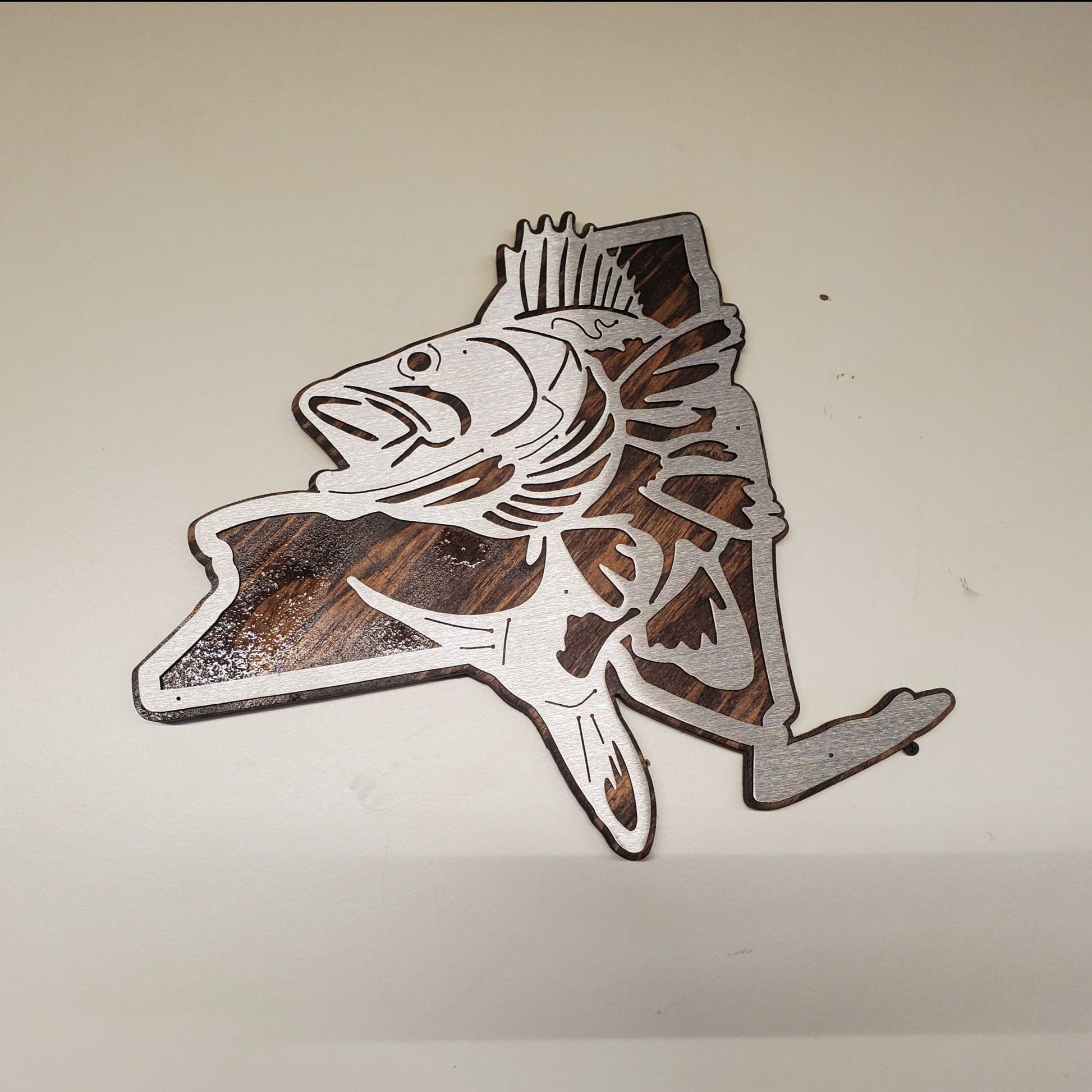 CNC metal cut out of the state of New York with a Walleye fish in the center, mounted on a stained wood background. Available in multiple sizes and customizable for any state shape. Made in a small family shop in America.