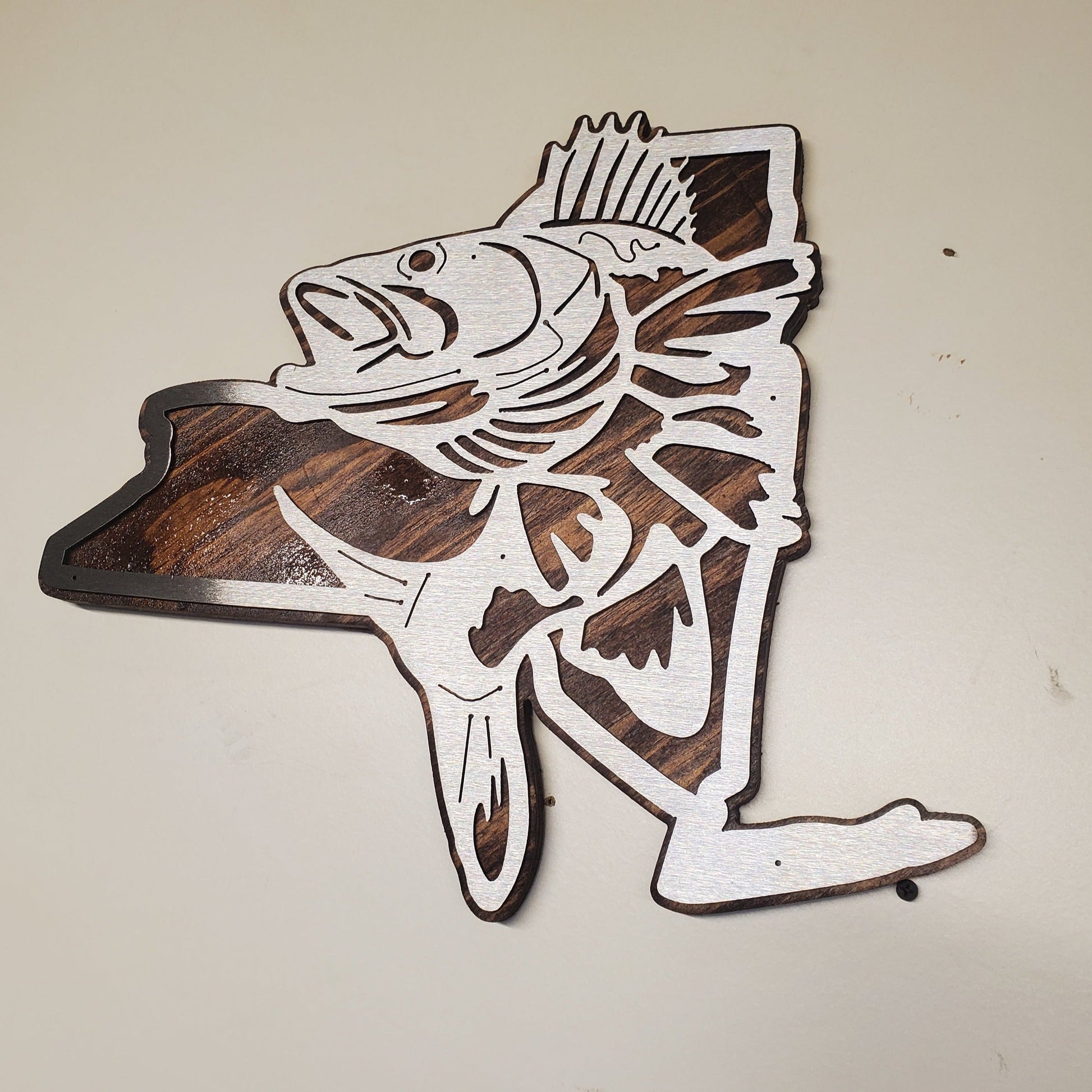 CNC metal cut out of the state of New York with a Walleye fish in the center, mounted on a stained wood background. Available in multiple sizes and customizable for any state shape. Made in a small family shop in America.