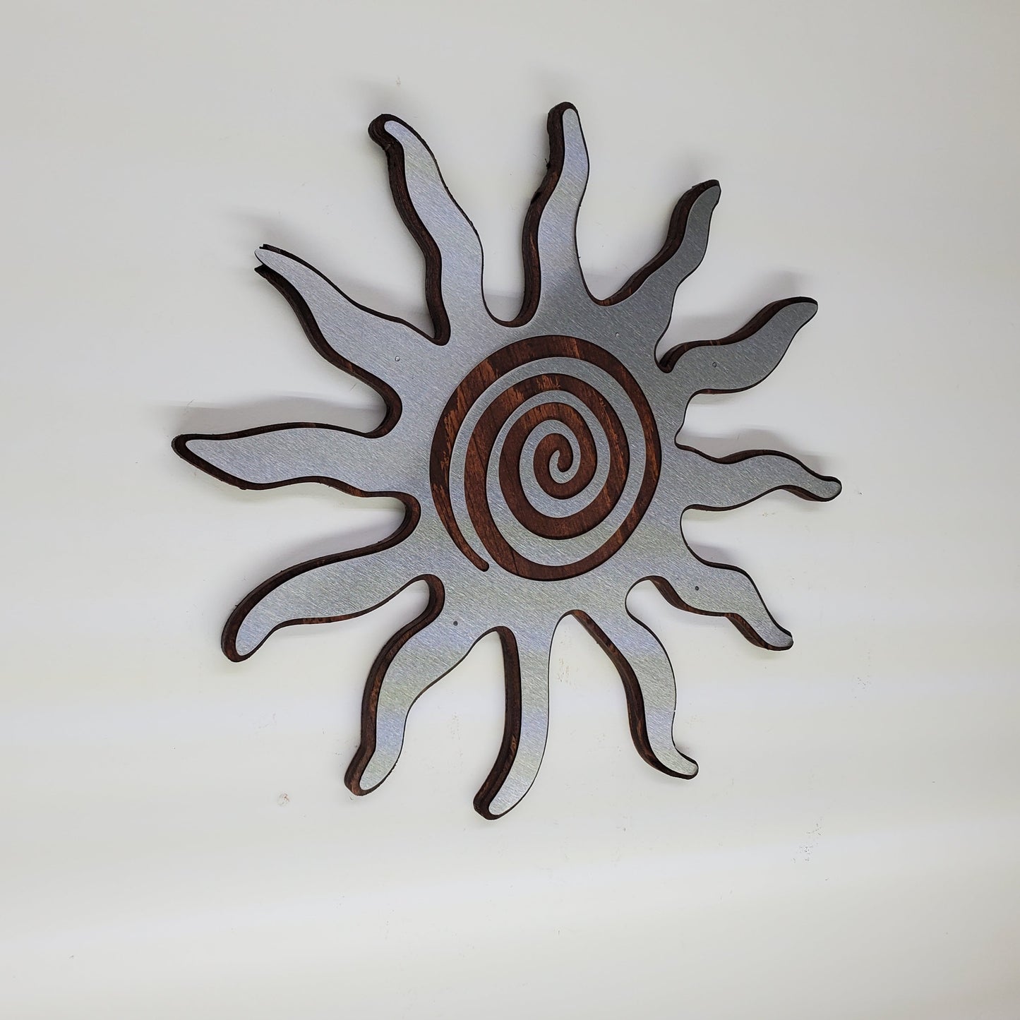 southwestern sun metal art wall decor on stained wood background.