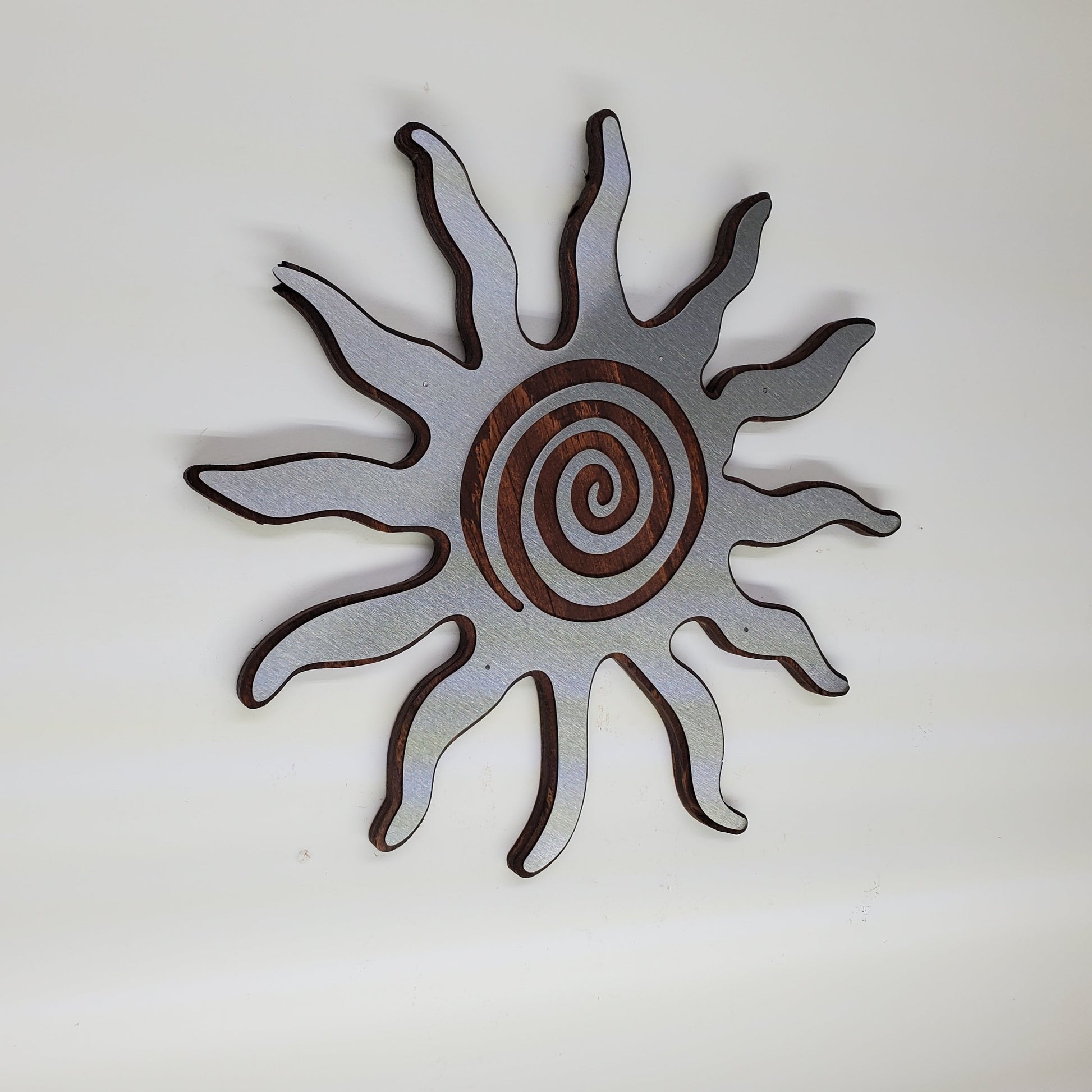 southwestern sun metal art wall decor on stained wood background.