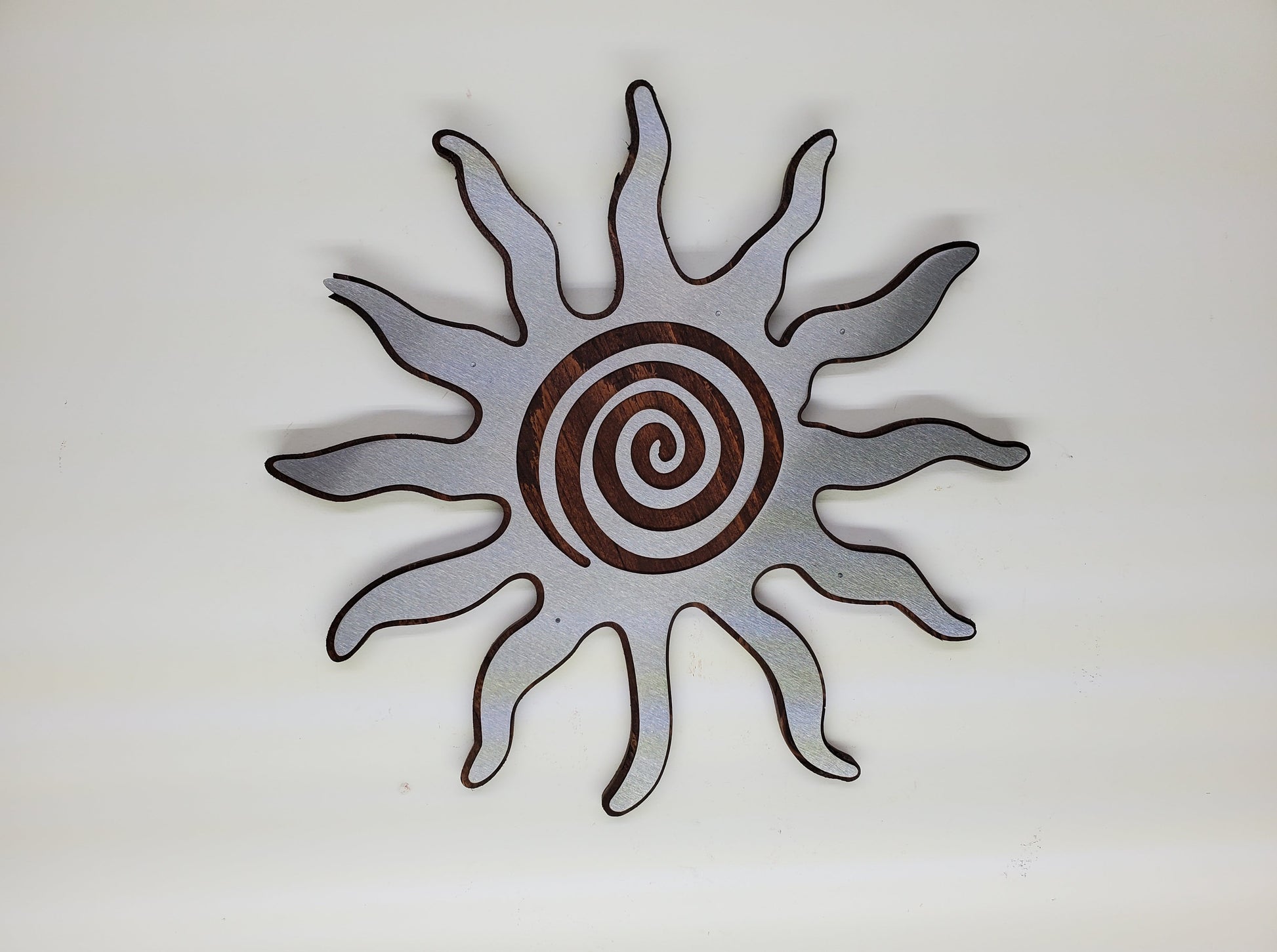 southwestern sun metal art wall decor on stained wood background.
