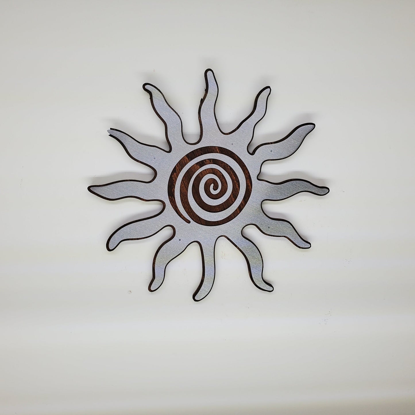 southwestern sun metal art wall decor on stained wood background. 