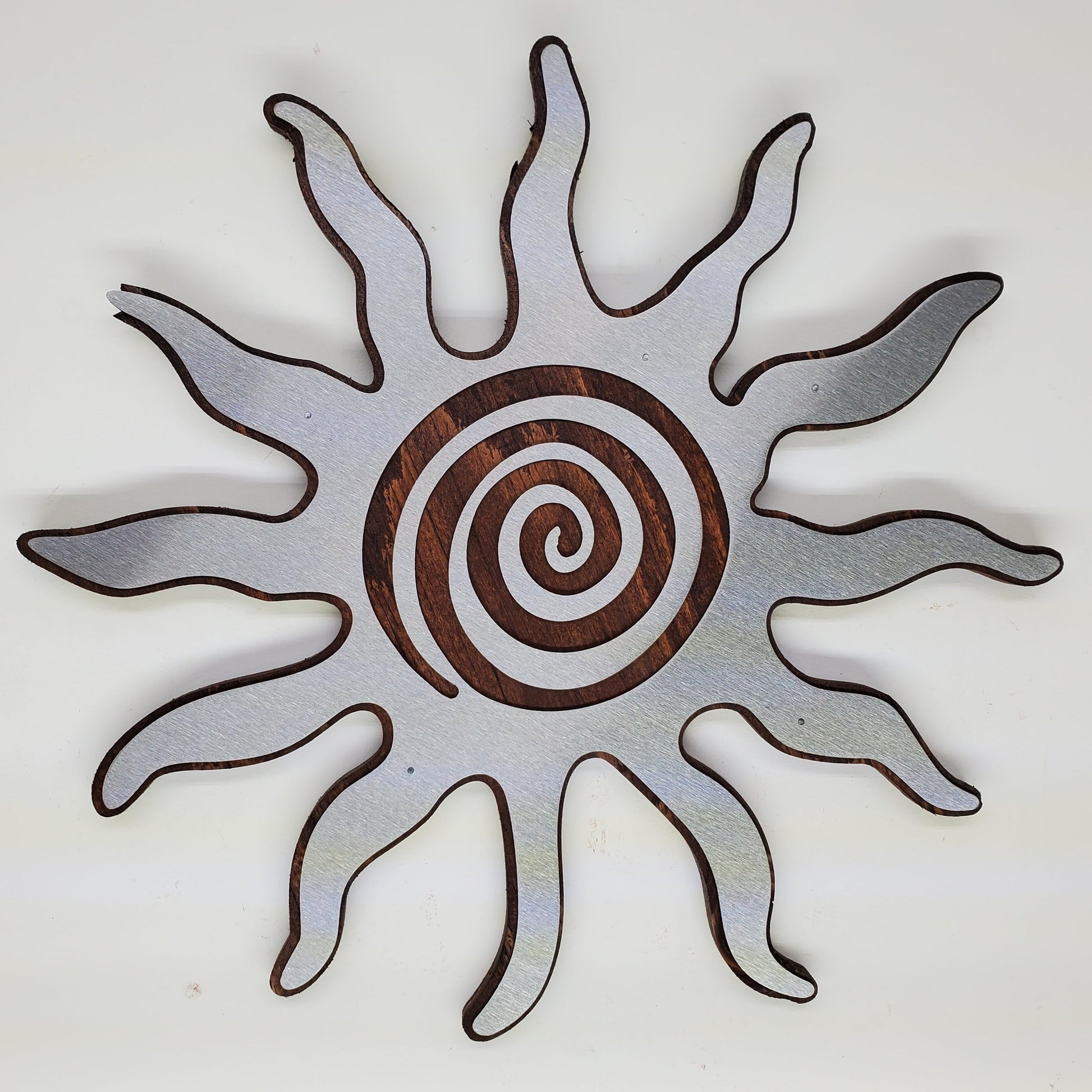 southwestern sun metal art wall decor on stained wood background.