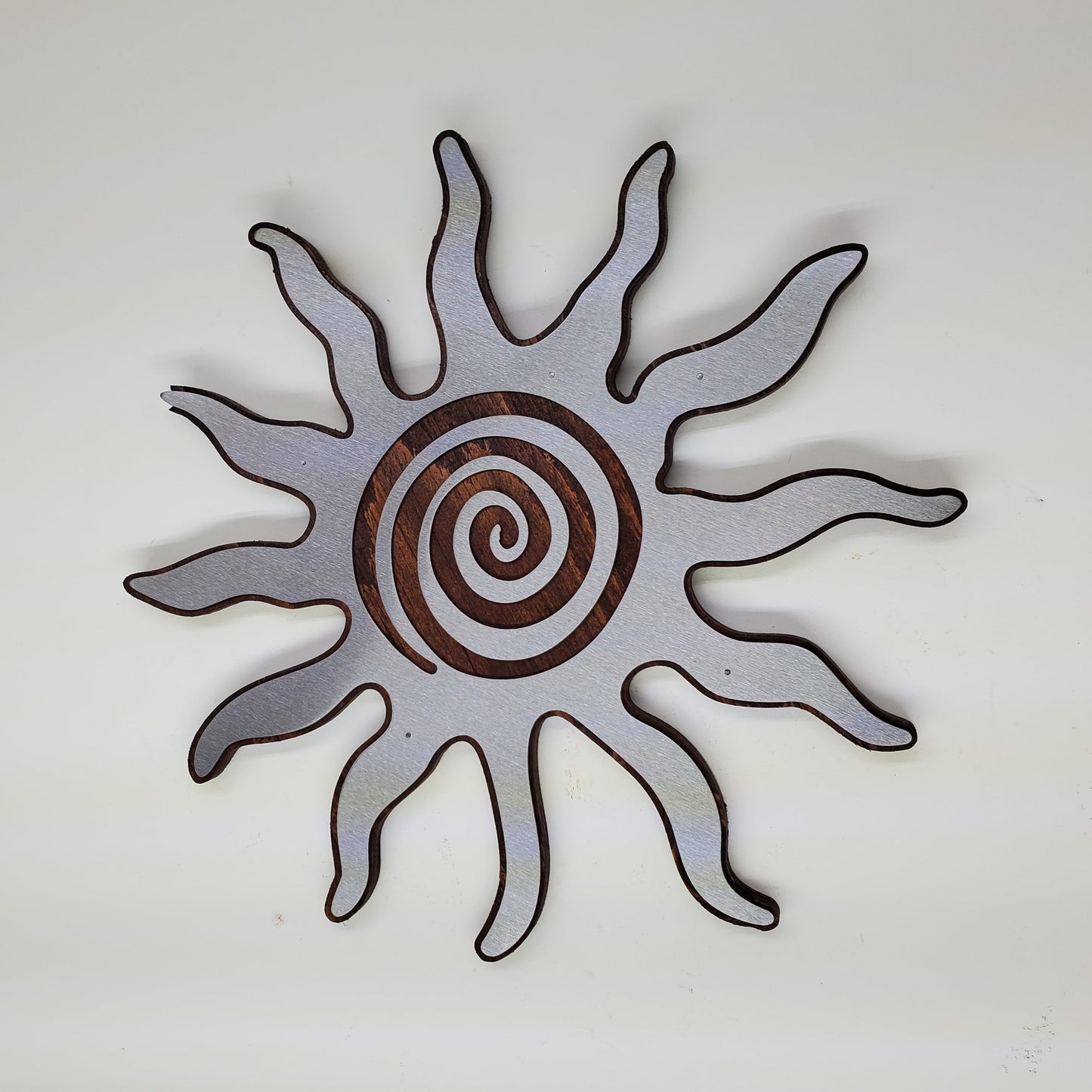 southwestern sun metal art wall decor on stained wood background.