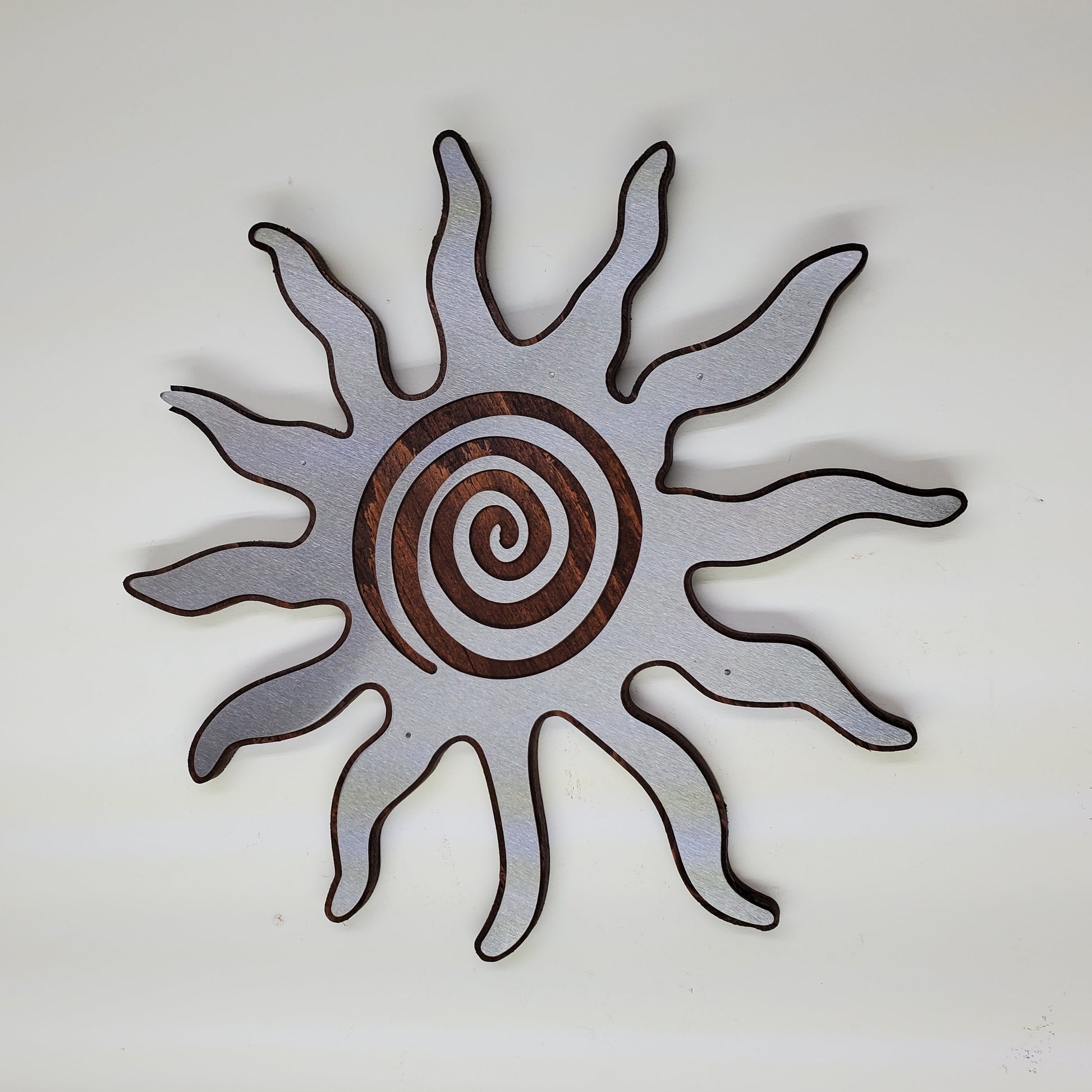 southwestern sun metal art wall decor on stained wood background.